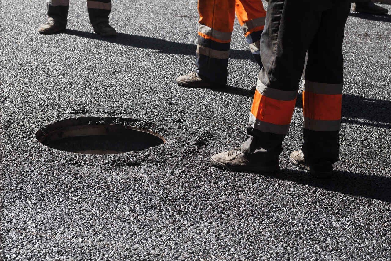 Geteerte Straße mit Gulli